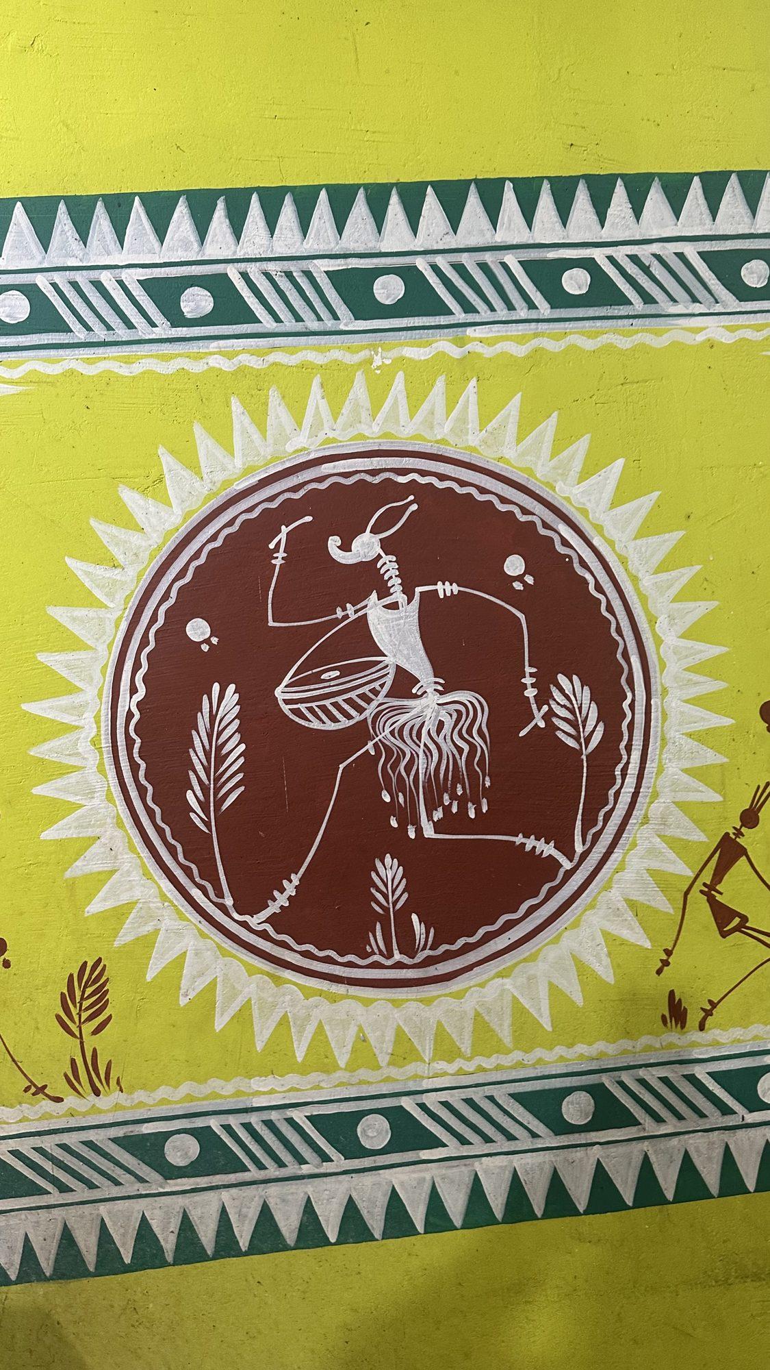 Folk-art wall painting of a drummer dancing inside a circular frame