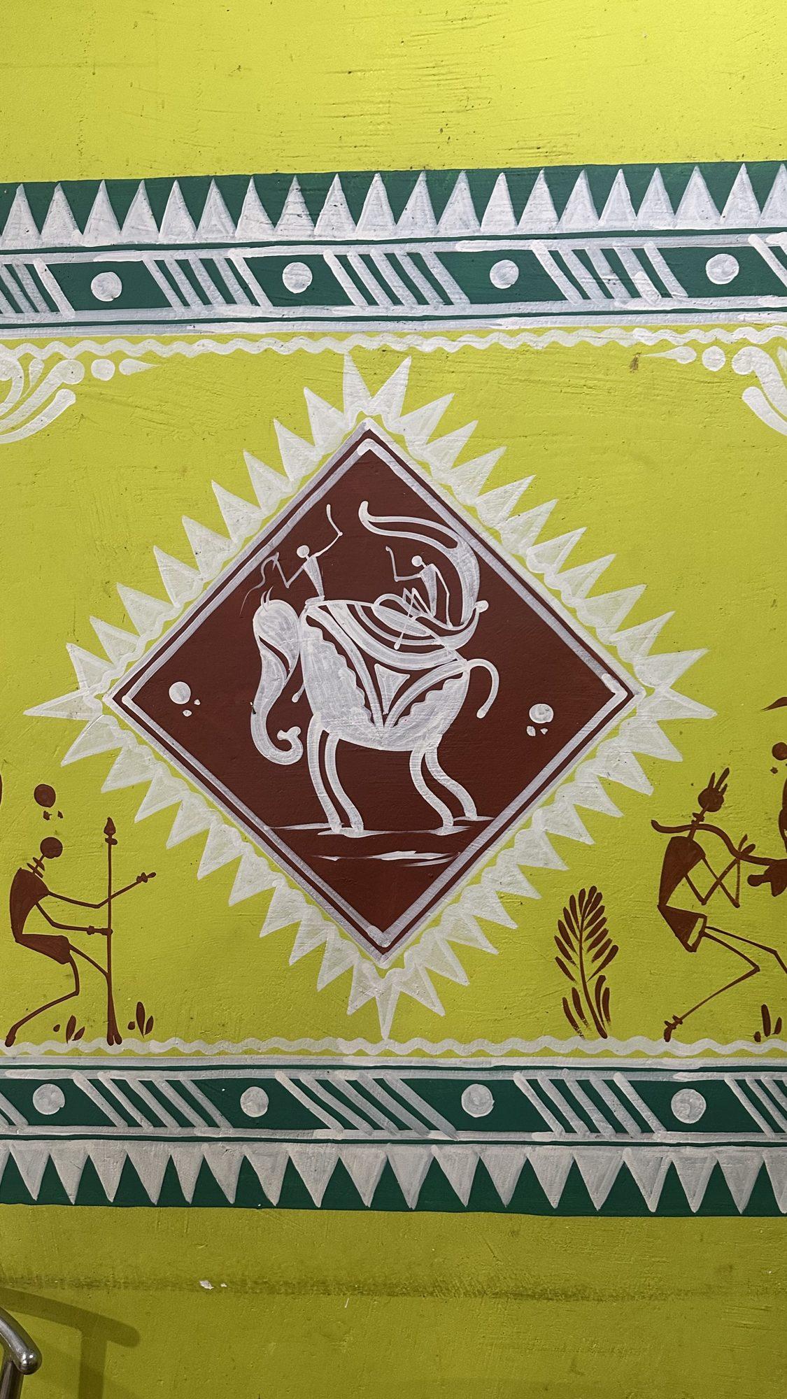 Folk-art wall painting of an elephant inside a diamond frame