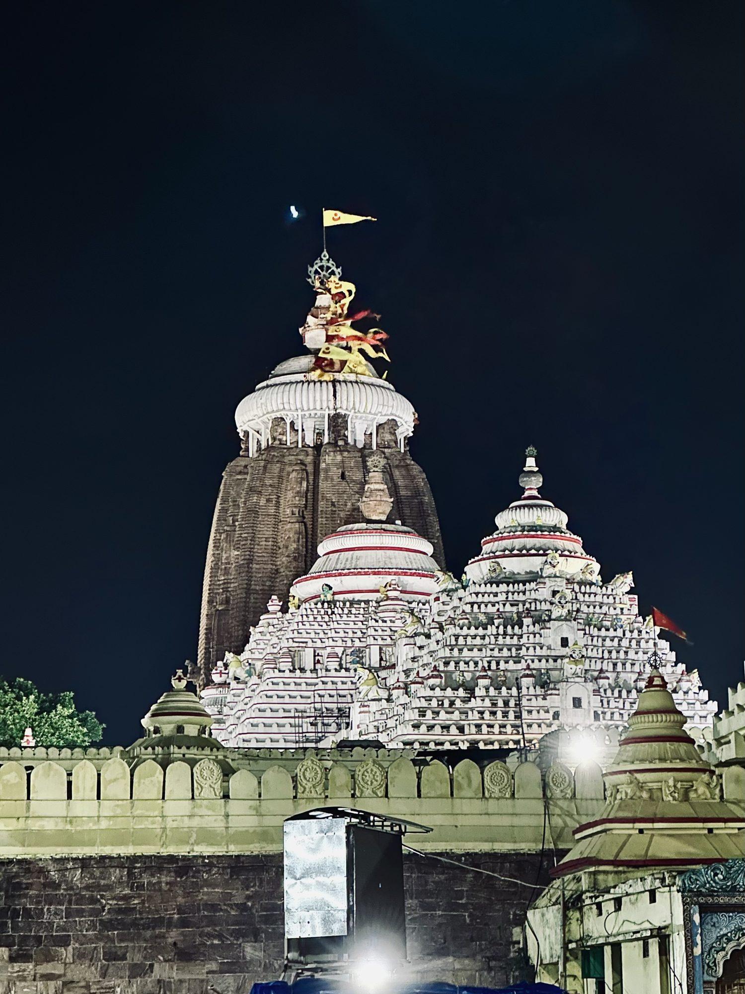 The Jagannath Temple in Puri lit at night with the flag on top